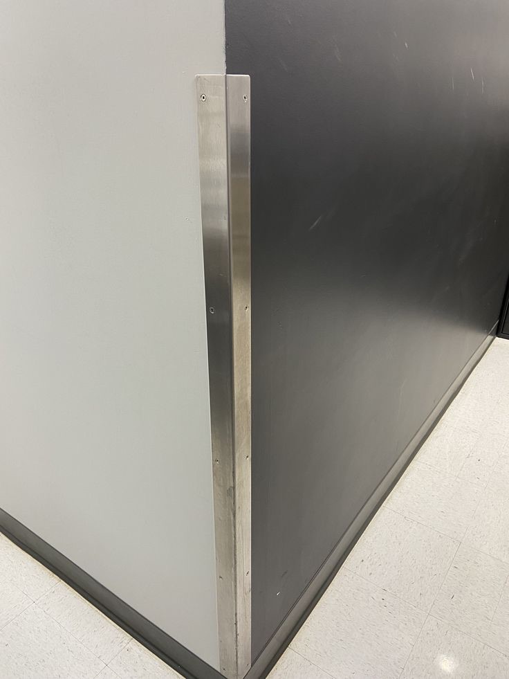 Stainless corner guard fitted to a wall
