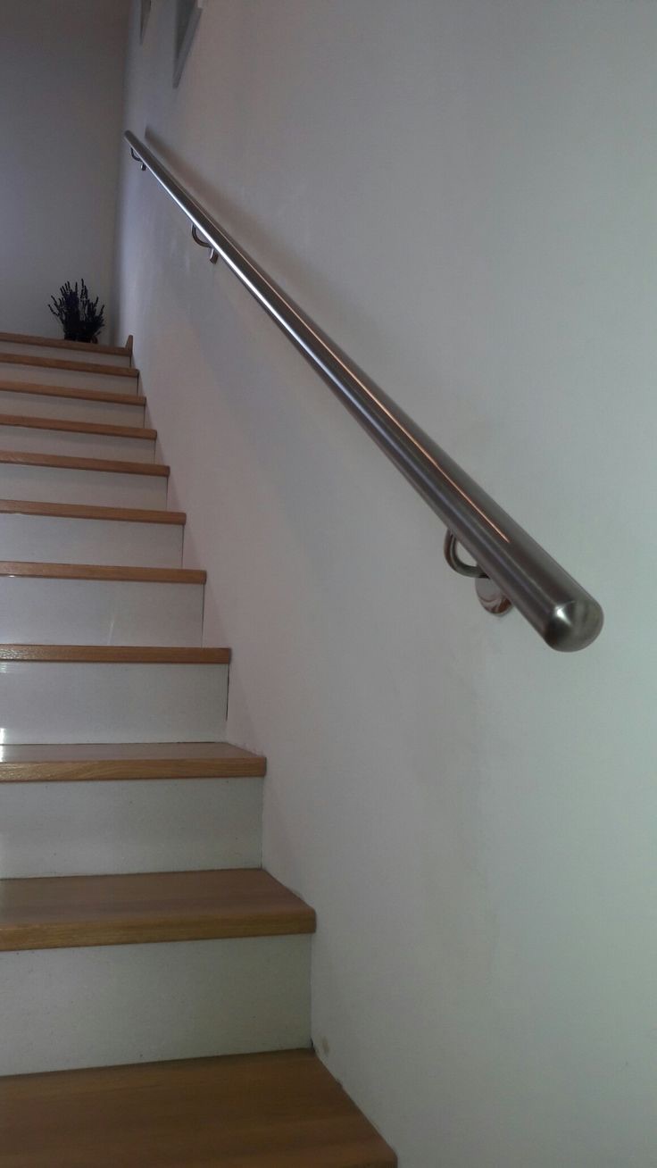 Wall-mounted stainless handrail on an internal staircase